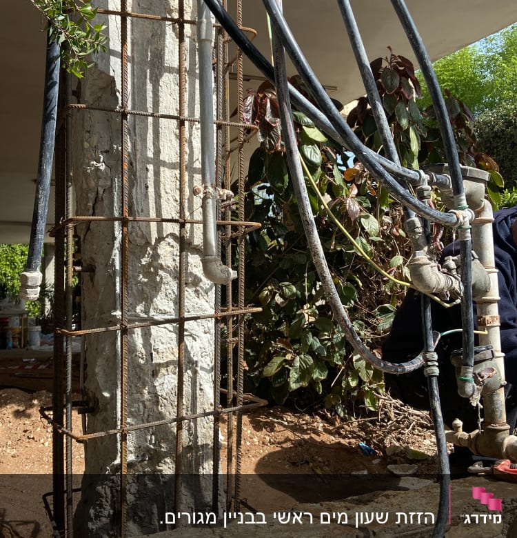 צינורות מים מחוברים לעמוד בטון עם ברזים